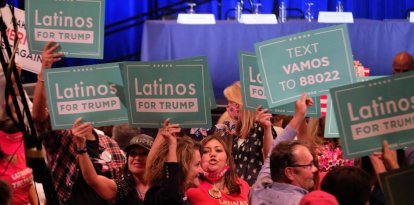 Hispanos con carteles que rezan "Latinos for Trump" en 2020.