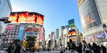 Unos peatones caminan por el cruce de Shibuya mientras un vídeo promocional (arriba) con imágenes de "Final Fantasy VII Rebirth" -la última entrega de la franquicia de videojuegos desarrollada y publicada por la compañía japonesa Square Enix- se muestra en grandes pantallas en la zona de Shibuya, en Tokio, el 27 de febrero de 2024. Final Fantasy VII Rebirth saldrá a la venta el 29 de febrero.