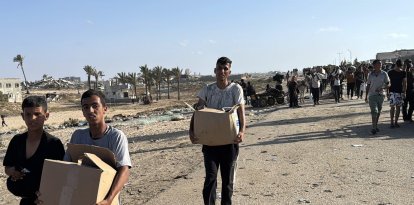 Palestinians carry humanitarian aid in Gaza