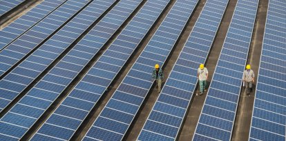 Unos trabajadores comprueban los paneles solares de una central fotovoltaica en el tejado de una fábrica del condado de Changxing, en la provincia de Zhejiang, al este de China.