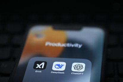 Una persona mira en la pantalla de su móvil aplicaciones con sistemas de inteligencia artificial