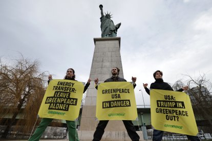 France's Greenpeace activists perform an action to support Greenpeace USA, next to Statue of Liberty at Pont de Grenelle in Paris on February 20, 2025. Energy Transfer, the Big Oil company behind the Dakota Access Pipeline, is suing Greenpeace USA for $300 million. (Photo by Thibaud MORITZ / AFP)