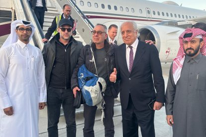 Ciudadano estadounidense George Glezmann (C) con funcionarios tras ser liberado
