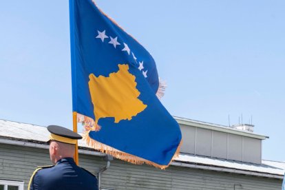 Un militar ondea la bandera de Kosovo