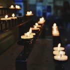 Imagen de archivo de unas velas de plegaria encendidas dentro de una iglesia.
