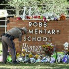 Un agente de policía de Uvalde deposita un peluche en la escuela en la que se produjo la masacre.