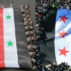 (COMBO) This combination of pictures created on December 13, 2024 shows (L) young Syrian members of the scout movement marching with the national flag during a celebration of Evacuation Day, commemorating independence from the French mandate in 1946, in Damascus on April 17, 2019; and (L) an aerial view showing crowds holding a giant independence-era flag, used by the opposition since the uprising began in 2011, during celebrations of the ouster of president Bashar al-Assad in Damascus on December 13, 2024. (Photo by LOUAI BESHARA and Omar HAJ KADOUR / AFP)