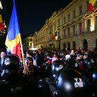 Un partidario del candidato presidencial Calin Georgescu sostiene la bandera rumana.