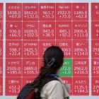 Una mujer observa un tablero electrónico que muestra el índice Nikkei 225 en la Bolsa de Tokio el 8 de abril de 2025